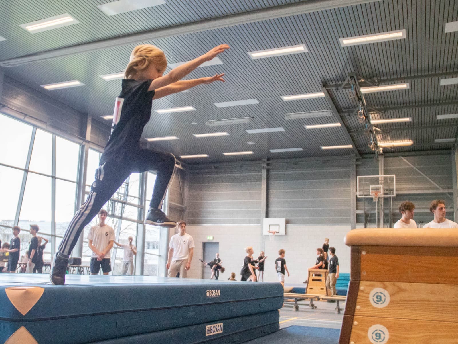 Een jonge freerunner oefent veilig op een dikke mat